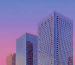 Modern glass skyscraper against sky at dusk, osaka