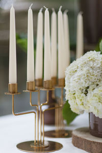 Close-up of white flower vase  and candle on table