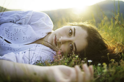 Portrait of woman lying down on field