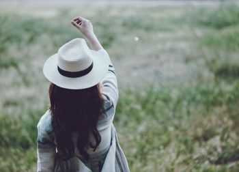 Rear view of woman standing on field