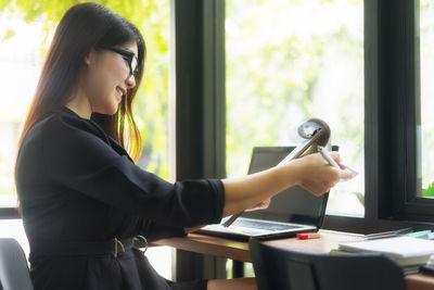 Businesswoman working at desk in cafe