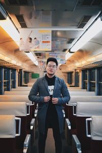 Portrait of young man standing against train