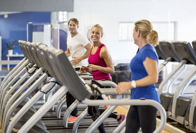 Friends exercising on treadmills at health club