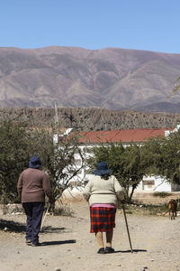 Rear view of people standing on landscape against clear sky