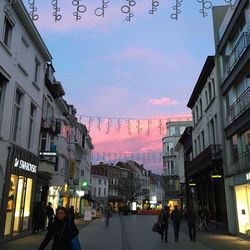 People walking on street in city against sky