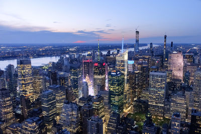 Illuminated cityscape against sky during sunset