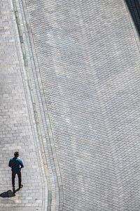 Rear view of man walking on footpath