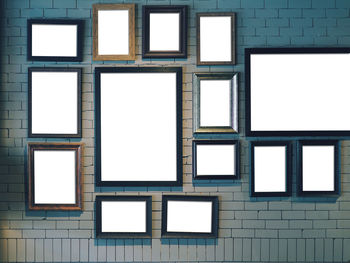 Close-up of blank picture frames against brick wall