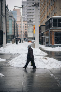 Full length of man walking on street during winter