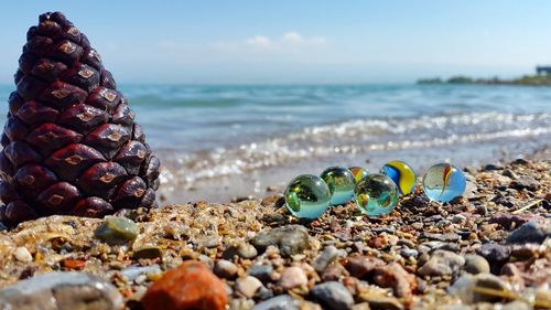 Close-up of pebbles on beach against sky