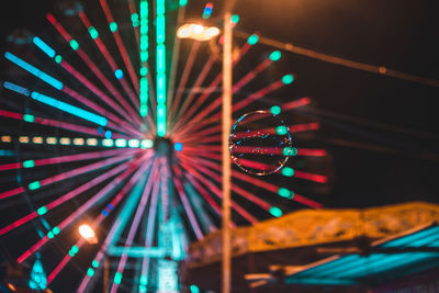 Low angle view of illuminated ferris wheel at night