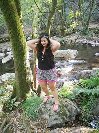 Full length portrait of young woman in forest