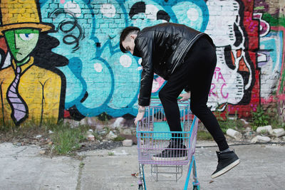 Man getting into shopping trolley