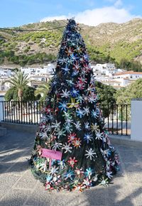 Multi colored christmas tree on street in city