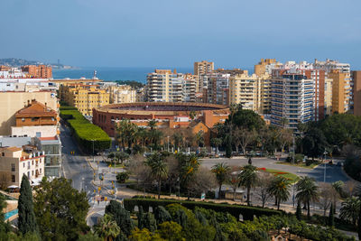 High angle view of buildings and trees against blue sky