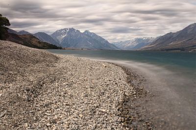 Scenic view of mountains and lake against cloudy sky