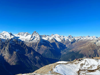 Scenic view of snowcapped mountains against clear blue sky