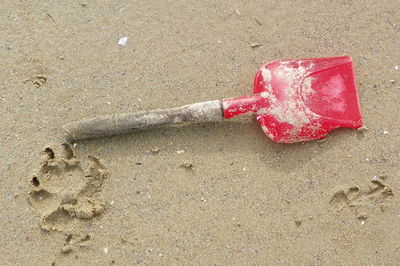 Close-up of red heart shape on sand