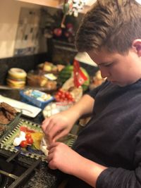 Midsection of boy holding food at home
