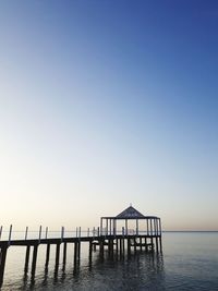 Pier over sea against clear sky