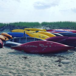 Boats moored on beach against sky