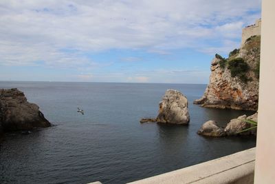 Rocks in sea against sky