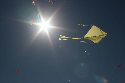 Low angle view of kite flying against sky on sunny day