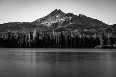 Scenic view of lake by snowcapped mountains against sky