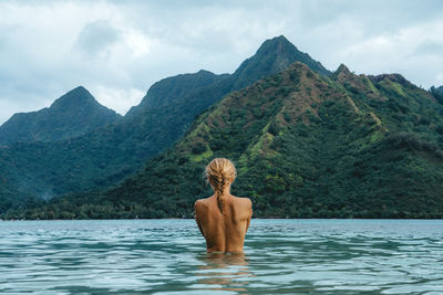 Rear view of shirtless man in water