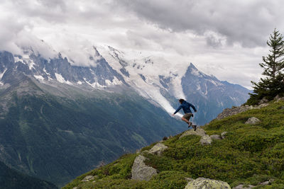 Rear view of man on mountain against sky