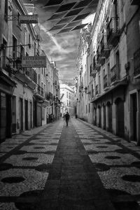 Rear view of man walking on street in city