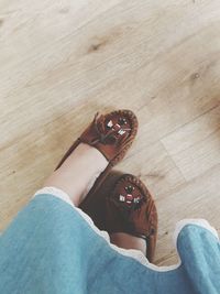 Low section of woman standing on hardwood floor