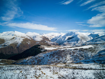 Scenic view of snowcapped mountains against blue sky