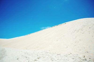 Scenic view of desert against clear blue sky