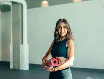 Portrait of beautiful woman standing against wall