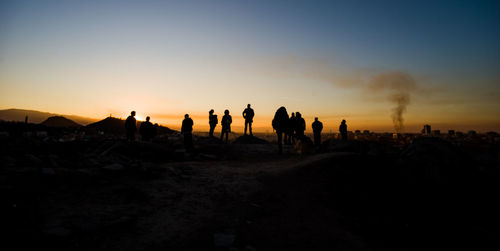 People's silhouettes on a golden hour cityscape background