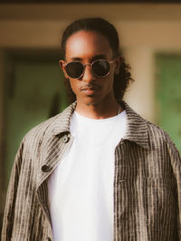 Portrait of young man wearing sunglasses standing outdoors