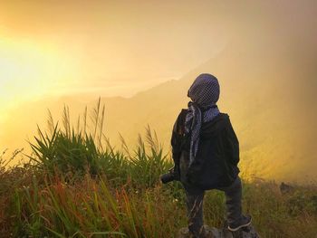 Rear view of man looking at sunset