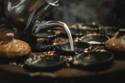 Close-up of drink pouring in container on table