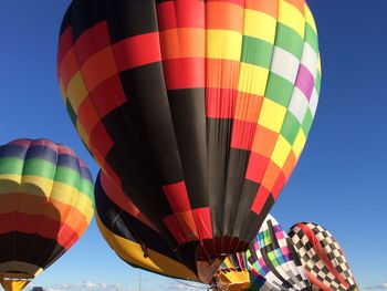 Low angle view of colorful balloons against blue sky