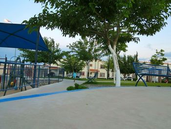 Swimming pool by trees against sky