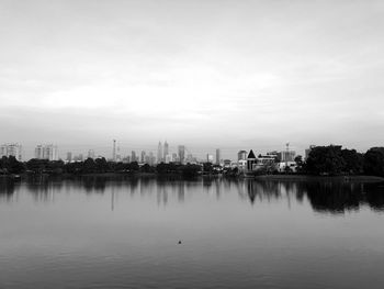 Scenic view of lake against sky in city