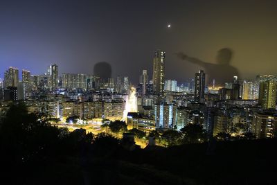 Illuminated cityscape against sky at night