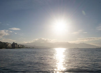 Scenic view of sea against bright sun