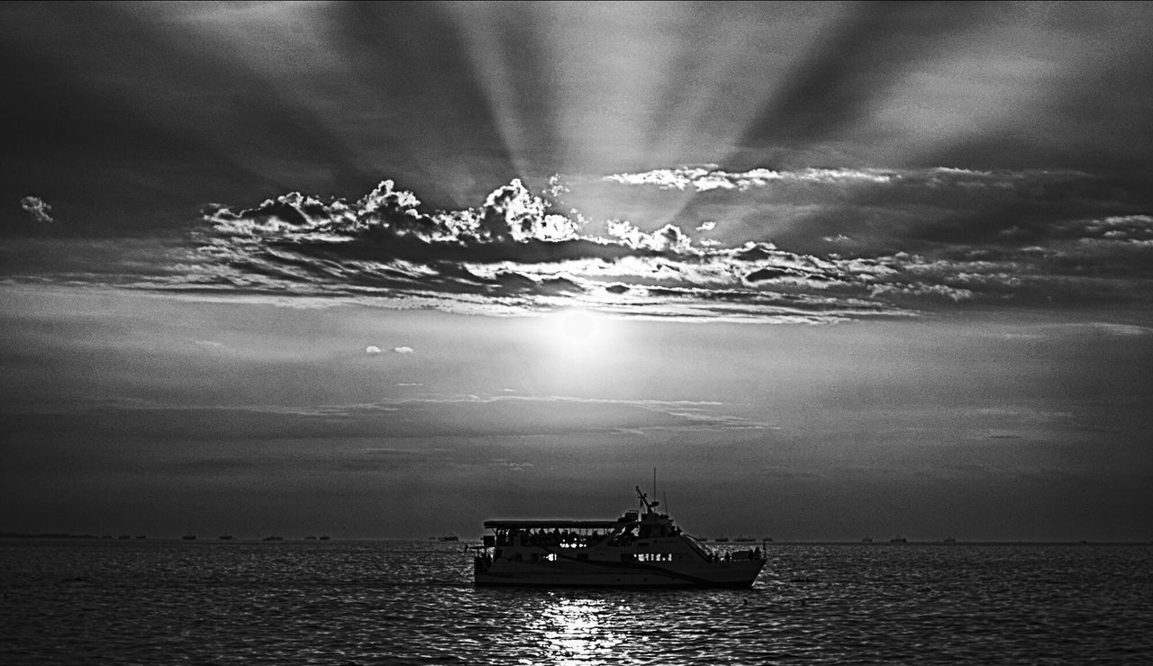 BOAT IN CALM SEA AGAINST DRAMATIC SKY