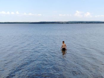 Man in sea against sky