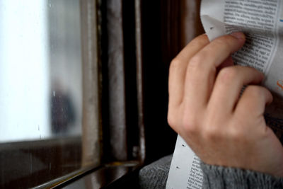 Midsection of man holding paper