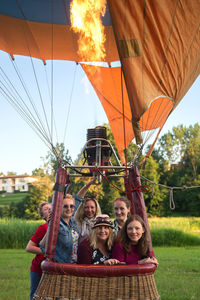 Family in hot air balloon against trees