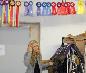 Portrait of woman standing below colorful hanging badges