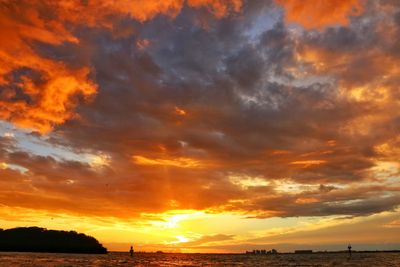 Scenic view of sea against dramatic sky during sunset